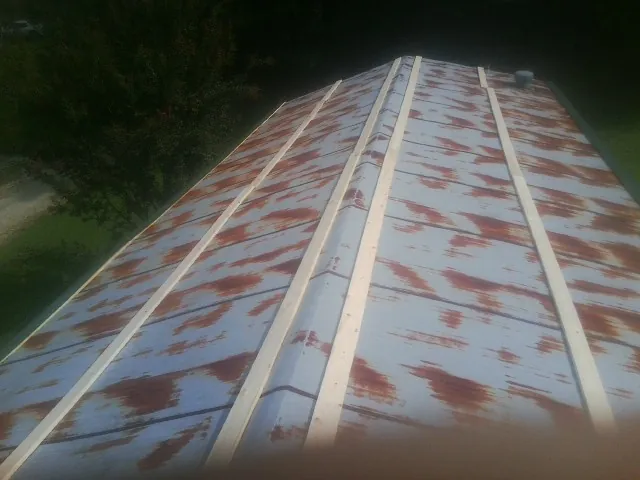 Rusted metal roof panels with new wood purlins before replacement — Storm Damage Roof Repair in Hatton by Roofing Brothers