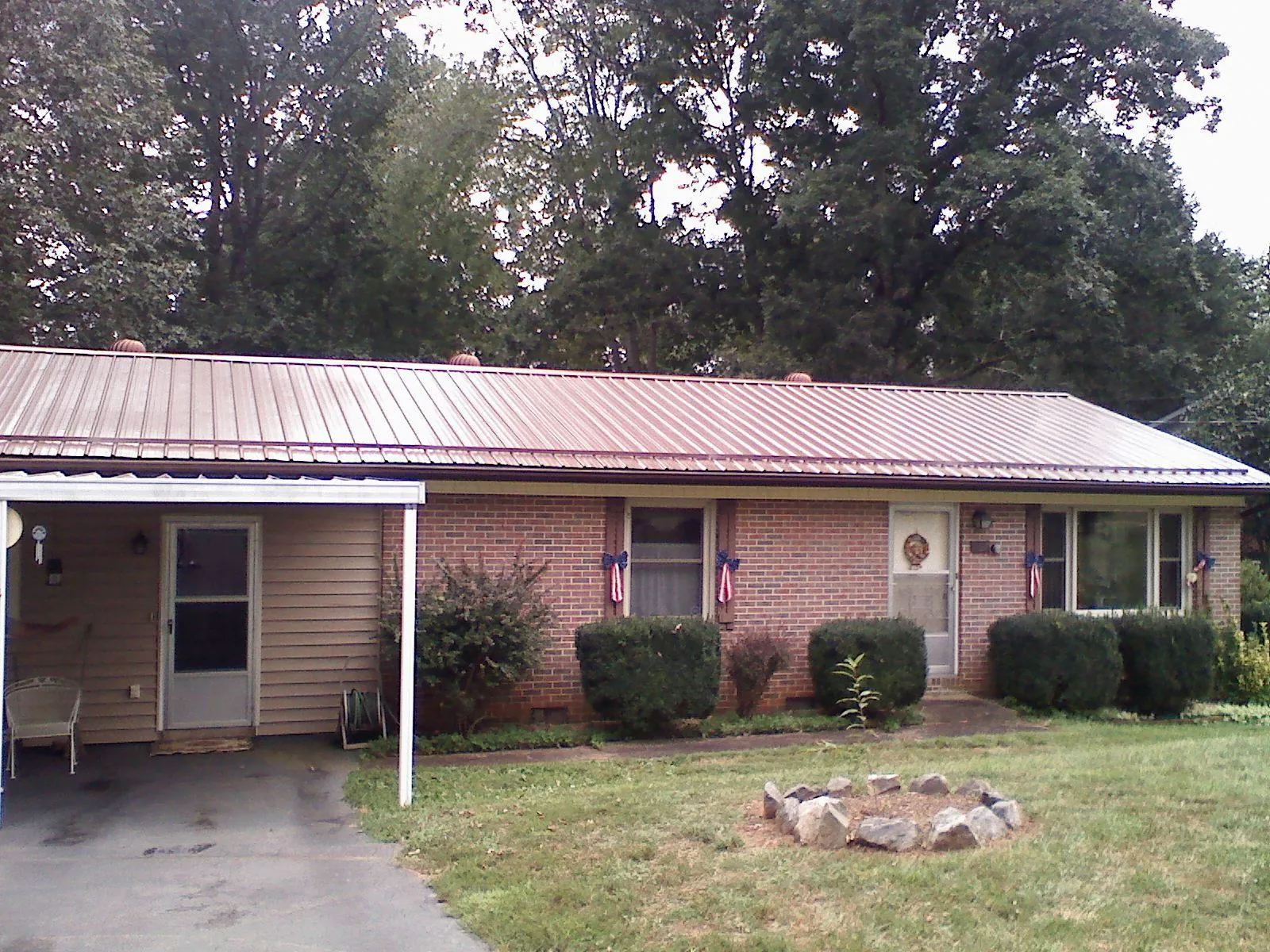 Bronze metal roof and carport on a brick ranch home — Roof Repair work by our crew in Hatton